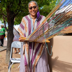 Artist at 2022 Market demonstrating her weaving artform